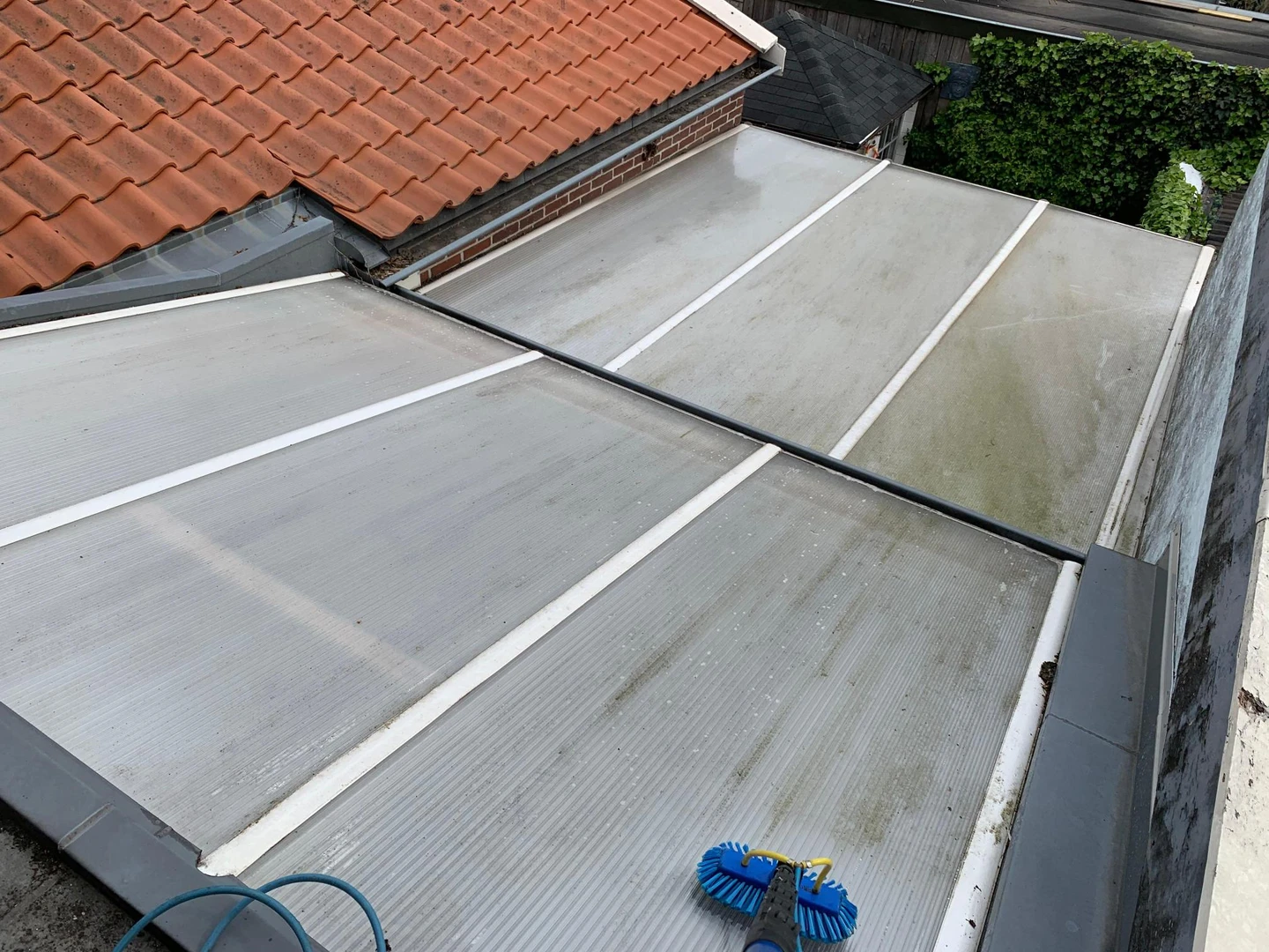 Overkapping met zichtbare vervuiling vóór reiniging
